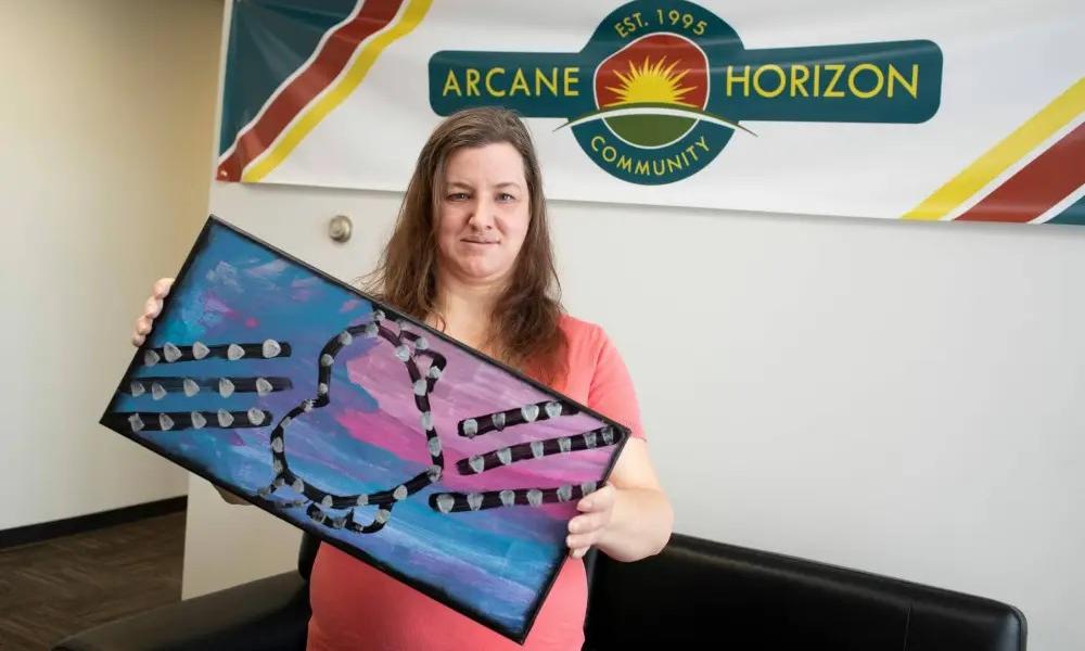Arcane Horizon artist holding a paintin